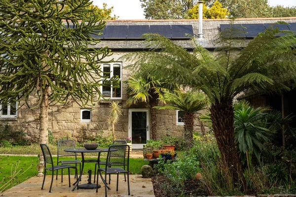 stone farmhouse surrounded by lush green foliage